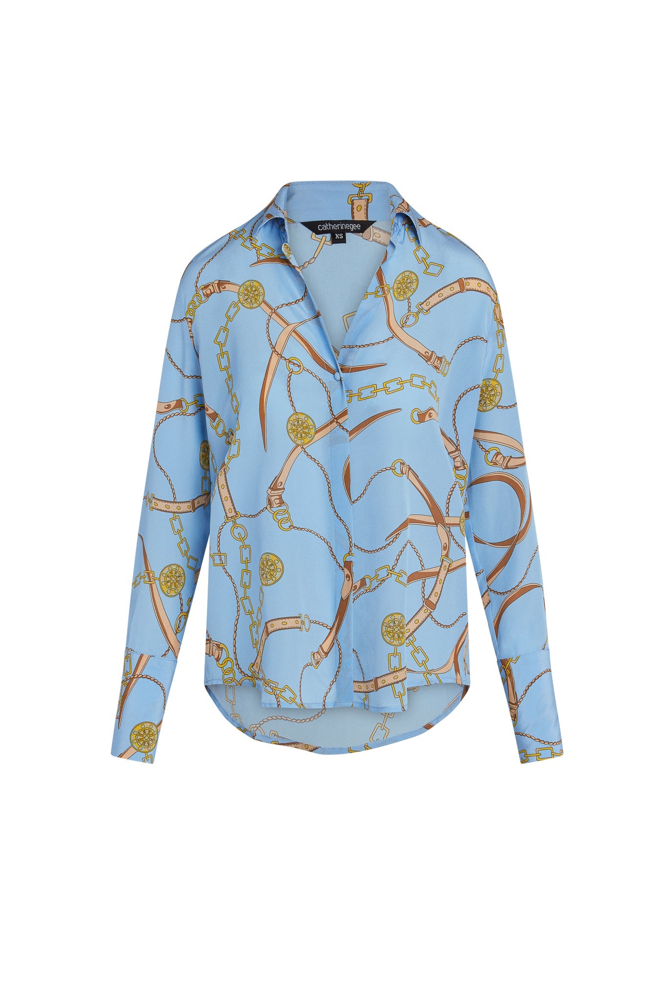 Catherine Gee Daria French Cuff Silk San Telmo blouse features a light blue base color with an intricate pattern of gold chains and buckles. The design includes long sleeves with French cuffs and a classic collar, and has a slightly loose fit, providing a sophisticated and elegant look suitable for various occasions. The luxurious silk fabric adds a touch of refinement and comfort.