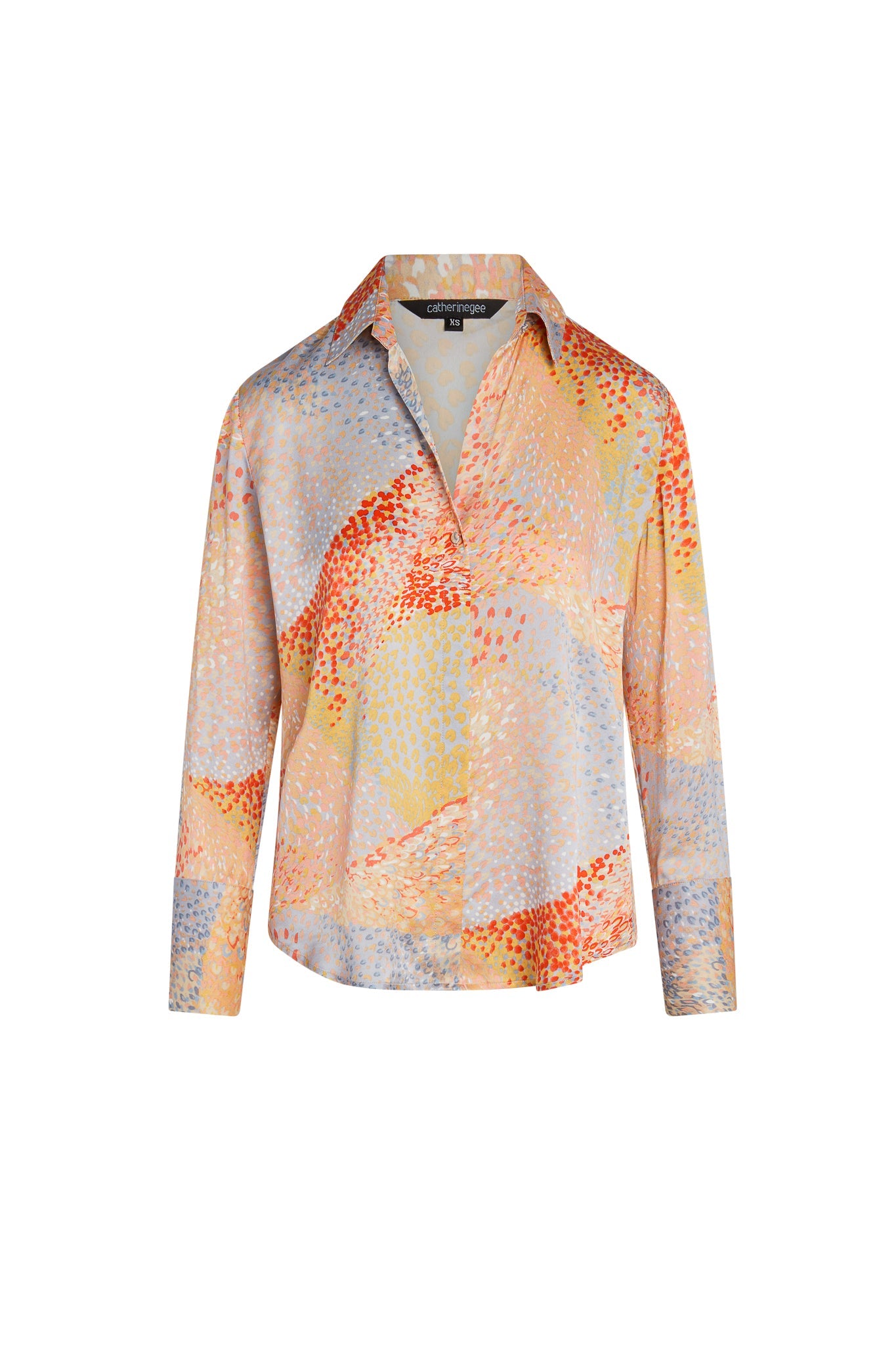 Catherine Gee Daria French Cuff Silk Warm Cosmos blouse features a vibrant, abstract pattern with a mix of warm colors including shades of orange, yellow, and blue. The design is reminiscent of a cosmic or celestial theme, with scattered dot-like patterns creating a dynamic and eye-catching look and has a classic collar, long sleeves with French cuffs, and a relaxed fit, making it both stylish and comfortable.