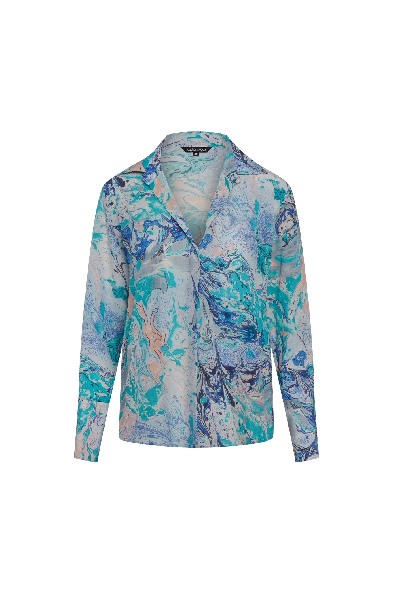 Catherine Gee Daria French Cuff Silk Blouse Cool Swirl. The blouse features a vibrant, abstract design with shades of blue, teal, and light peach. It has a classic collar, long sleeves with French cuffs, and a button-down front. The fabric appears lightweight and silky, giving it a luxurious and elegant look.