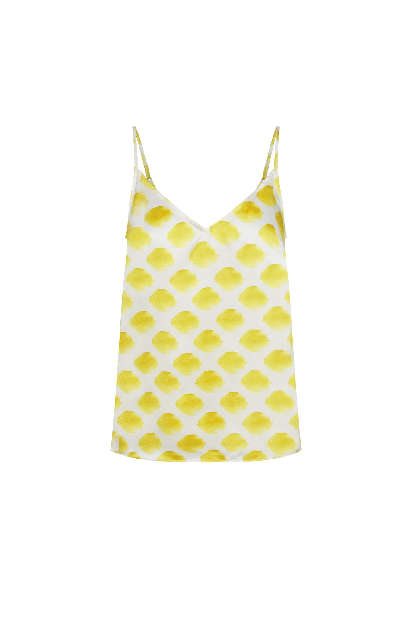Catherine Gee Franka Cami in Limon White. This stylish cami features a delicate spaghetti strap design with a V-neckline. The fabric is adorned with a pattern of yellow lemon-like shapes on a white background, giving it a fresh and summery look. The lightweight and airy material makes it perfect for warm weather, adding a touch of elegance and playfulness to any outfit.