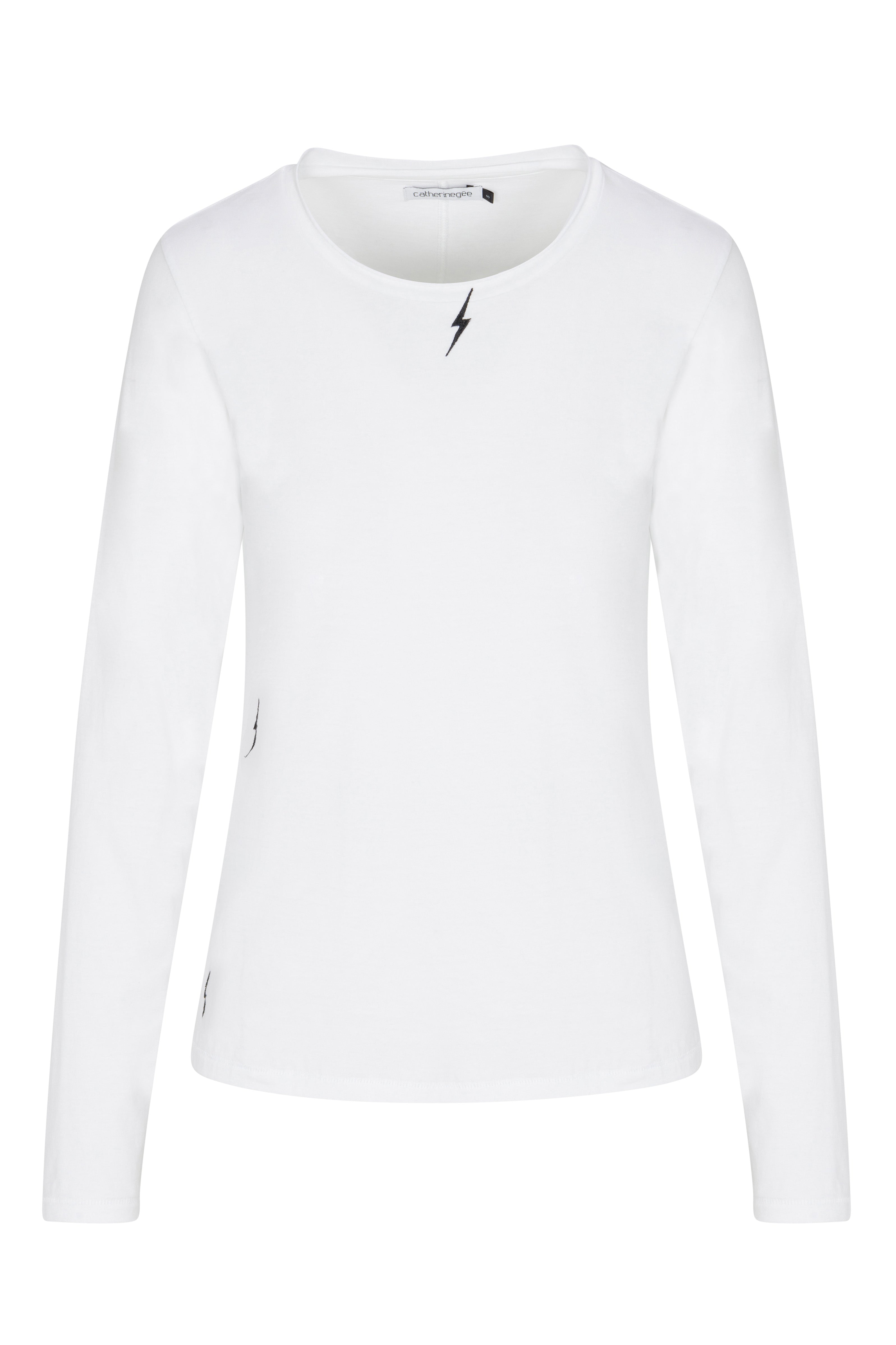Catherine Gee Embroidered Cotton White Long Sleeve Bolt T-Shirt. The shirt is plain white with a simple, minimalist design that features a small, black lightning bolt embroidery near the neckline, adding a subtle yet distinctive detail. The shirt has a round neckline and long sleeves, making it suitable for cooler weather. The clean and elegant design makes it versatile for various casual or semi-casual occasions.