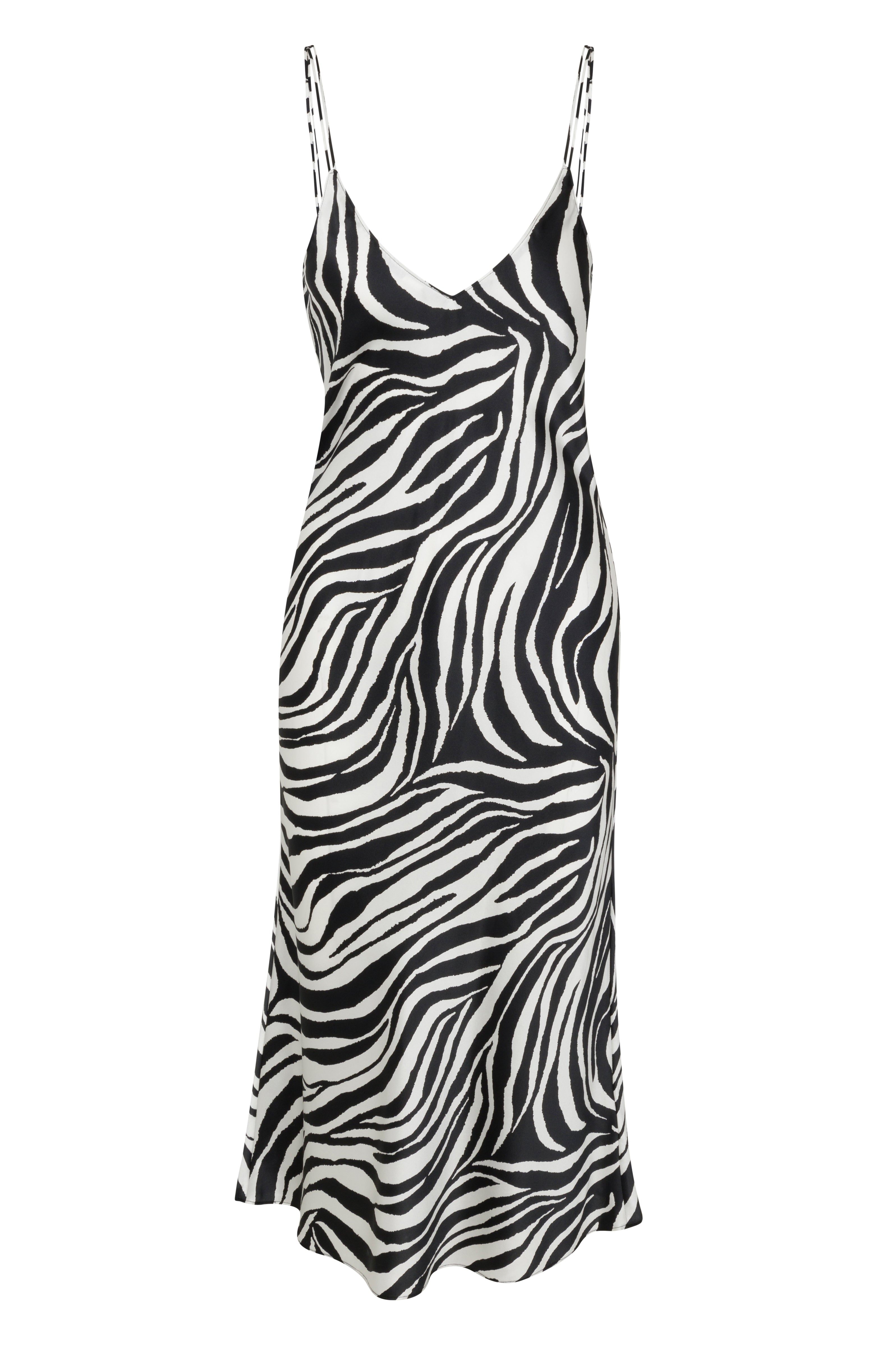 Catherine Gee Emma Zebra Slip dress features a striking zebra print pattern with black and white stripes. It has a V-neckline and thin spaghetti straps, creating a sleek and elegant silhouette. The dress appears to be made of a lightweight, flowy fabric, making it suitable for both casual and semi-formal occasions. The bold animal print adds a fashionable and eye-catching element to the design.