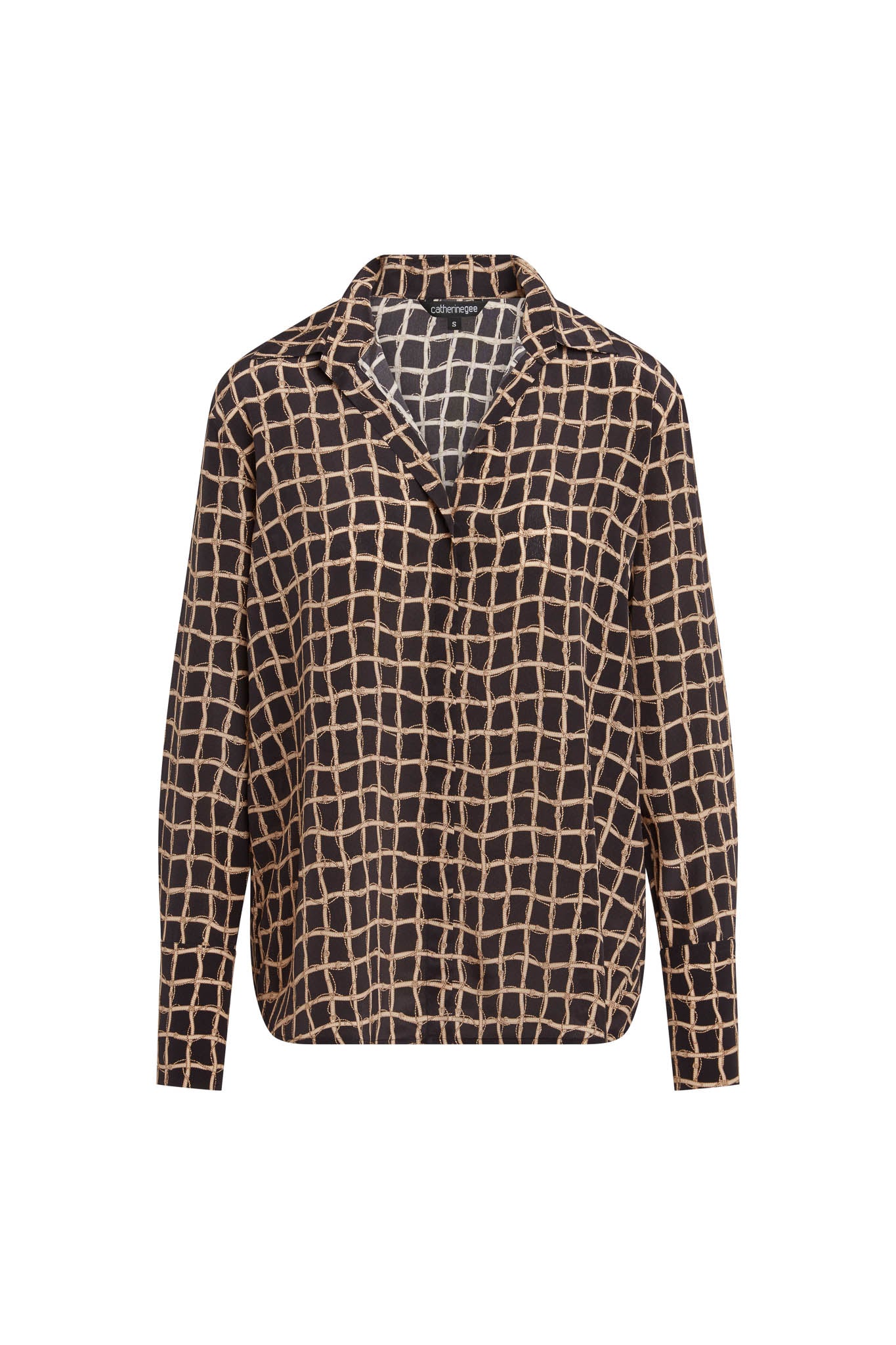 Catherine Gee Daria French Cuff Silk Recoleta features a black base with a beige grid pattern throughout. It has a relaxed fit with a V-neckline and a collar, and has long sleeves end in French cuffs, adding a sophisticated touch to the overall design. The silk material gives it a luxurious feel, making it suitable for both casual and formal occasions.