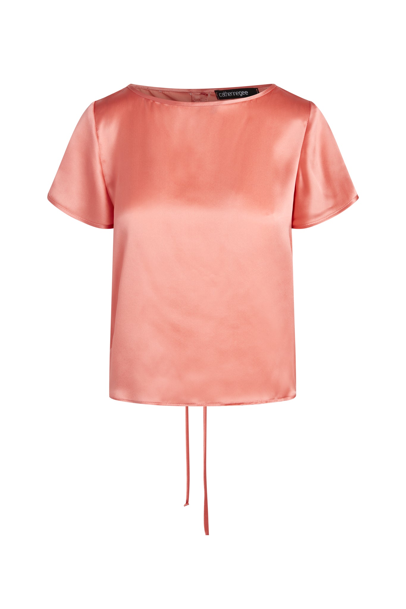 A Catherine Gee Cate Ruched Back Shirt in a soft pink satin fabric features short sleeves, a round neckline, and a slightly cropped hem with a drawstring detail at the back.