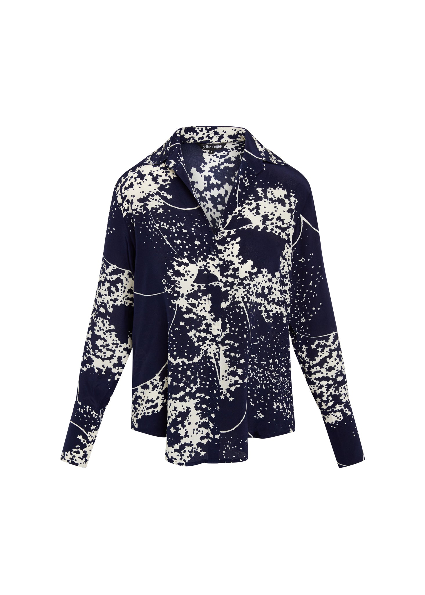 Catherine Gee Daria French Cuff Silk Blouse Cosmos Print features a dark blue base with white speckled patterns resembling stars and cosmic dust. It has a classic collar, long sleeves, and a button-down front, offering an elegant and sophisticated look suitable for both casual and formal occasions.