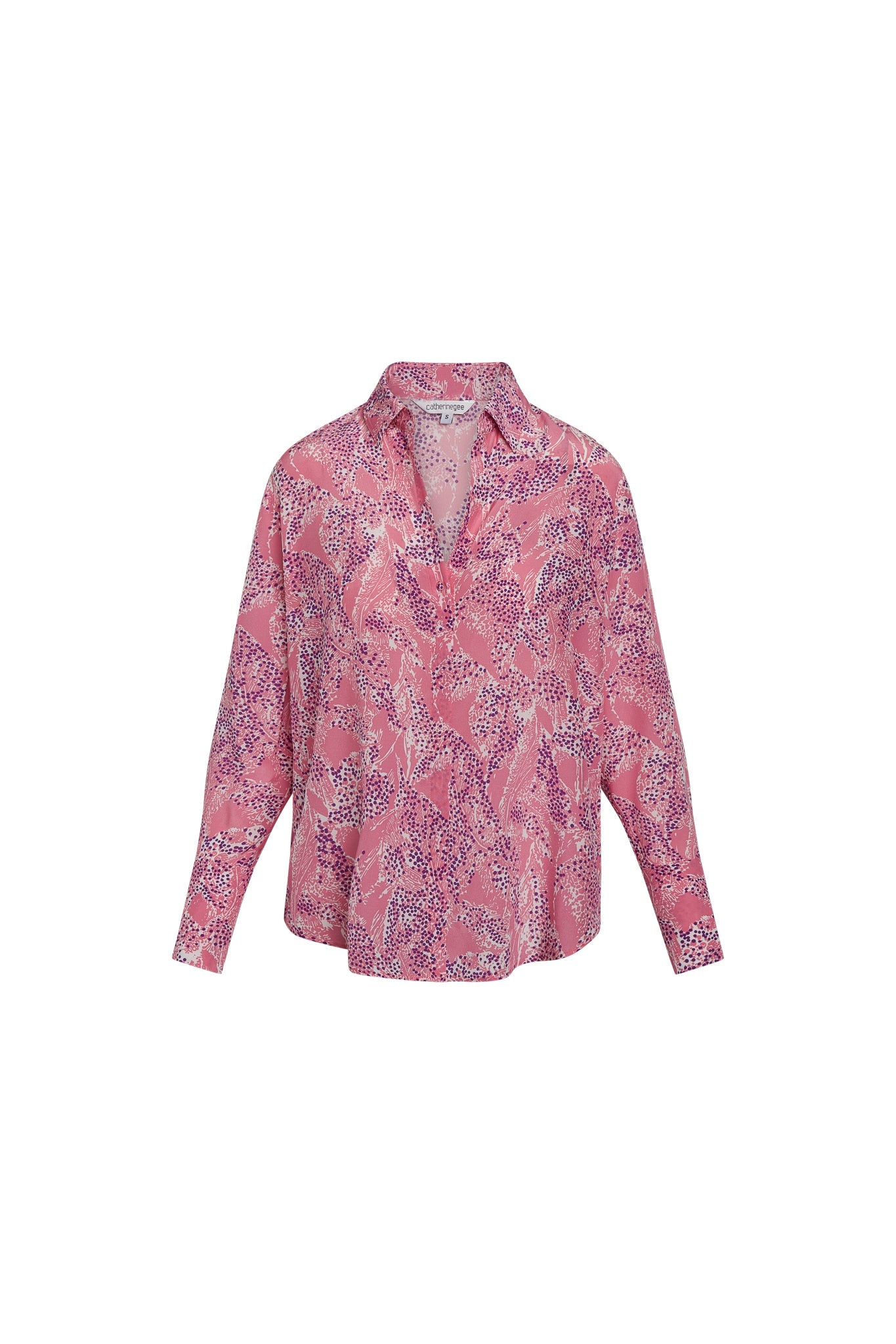 Catherine Gee Daria French Cuff Silk Pink Sea blouse features a vibrant pink color with a sea-inspired pattern that includes various shades of purple and white. It has a classic collar, long sleeves with French cuffs, and a relaxed fit. The silk material gives it a luxurious and smooth texture, making it suitable for both casual and formal occasions. The design is both elegant and eye-catching, making it a versatile addition to any wardrobe.