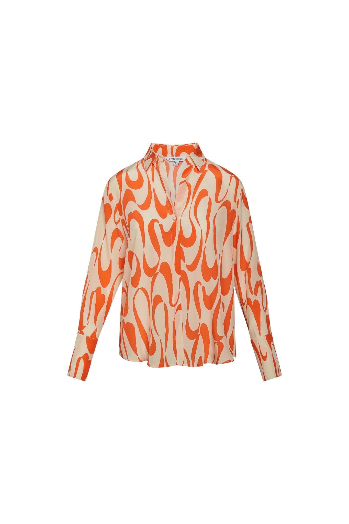 Catherine Gee Daria French Cuff Silk Valencia Blouse features a vibrant, abstract orange and cream pattern with long sleeves and a French cuff design. The fabric appears to be silk, giving it a luxurious and smooth texture, and has a relaxed fit with a slightly open collar, making it suitable for both casual and formal occasions. The bold pattern and high-quality material make it a standout piece in any wardrobe.