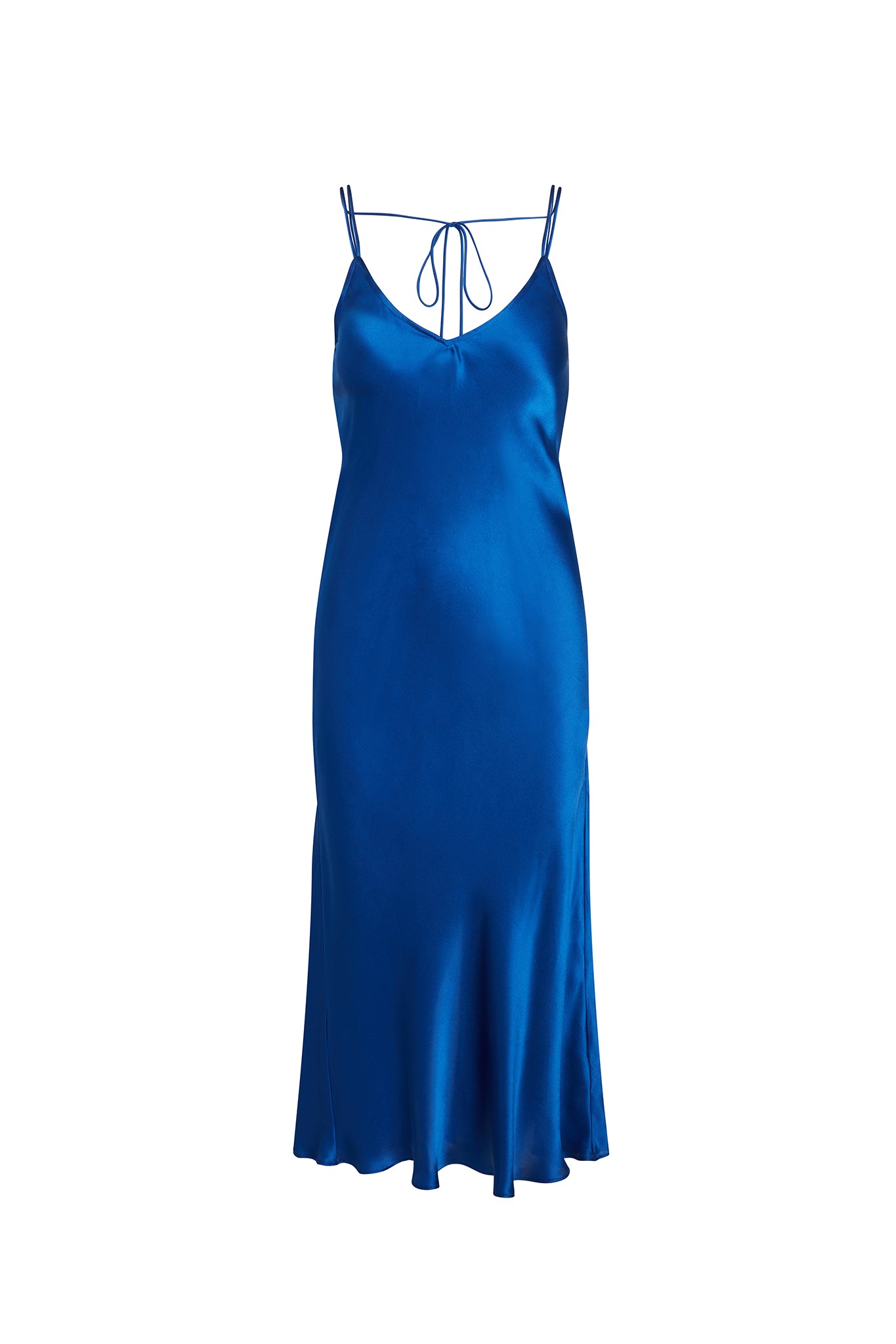 Catherine Gee Emma Mykonos Blue Slip Dress. This elegant dress features a rich, vibrant blue color and a silky, smooth texture, has thin spaghetti straps and a V-neckline with a delicate tie detail at the back. The dress falls gracefully to a midi length, with a slight flare at the hem, creating a sophisticated and timeless silhouette.