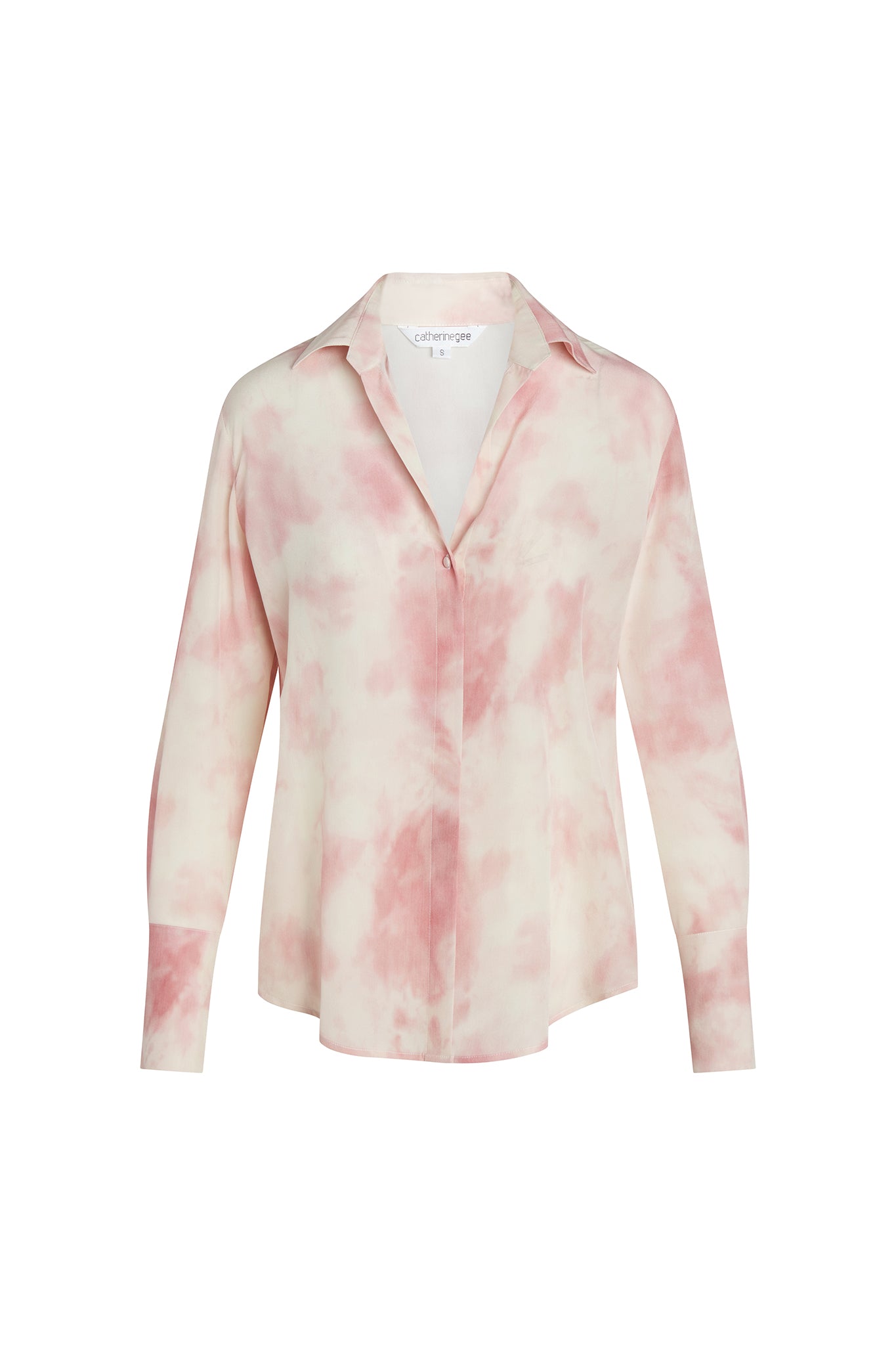 Catherine Gee Daria French Cuff Silk Pink Dye blouse features a soft, tie-dye pattern in shades of pink and white. It has a classic collar, long sleeves with French cuffs, and a button-down front. The fabric appears to be lightweight and silky, giving it a luxurious and elegant look, has a relaxed fit, making it suitable for both casual and semi-formal occasions.