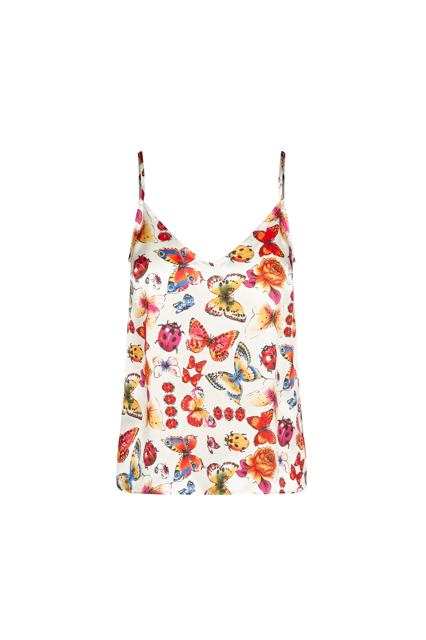 A woman wearing the Catherine Gee Franka Cami - Ladybug. This sleeveless cami features thin spaghetti straps and a V-neckline. The fabric showcases a vibrant and colorful print of butterflies, ladybugs, and flowers on a white background. The lively design makes it a standout piece, perfect for adding a playful and stylish touch to casual or semi-formal outfits.