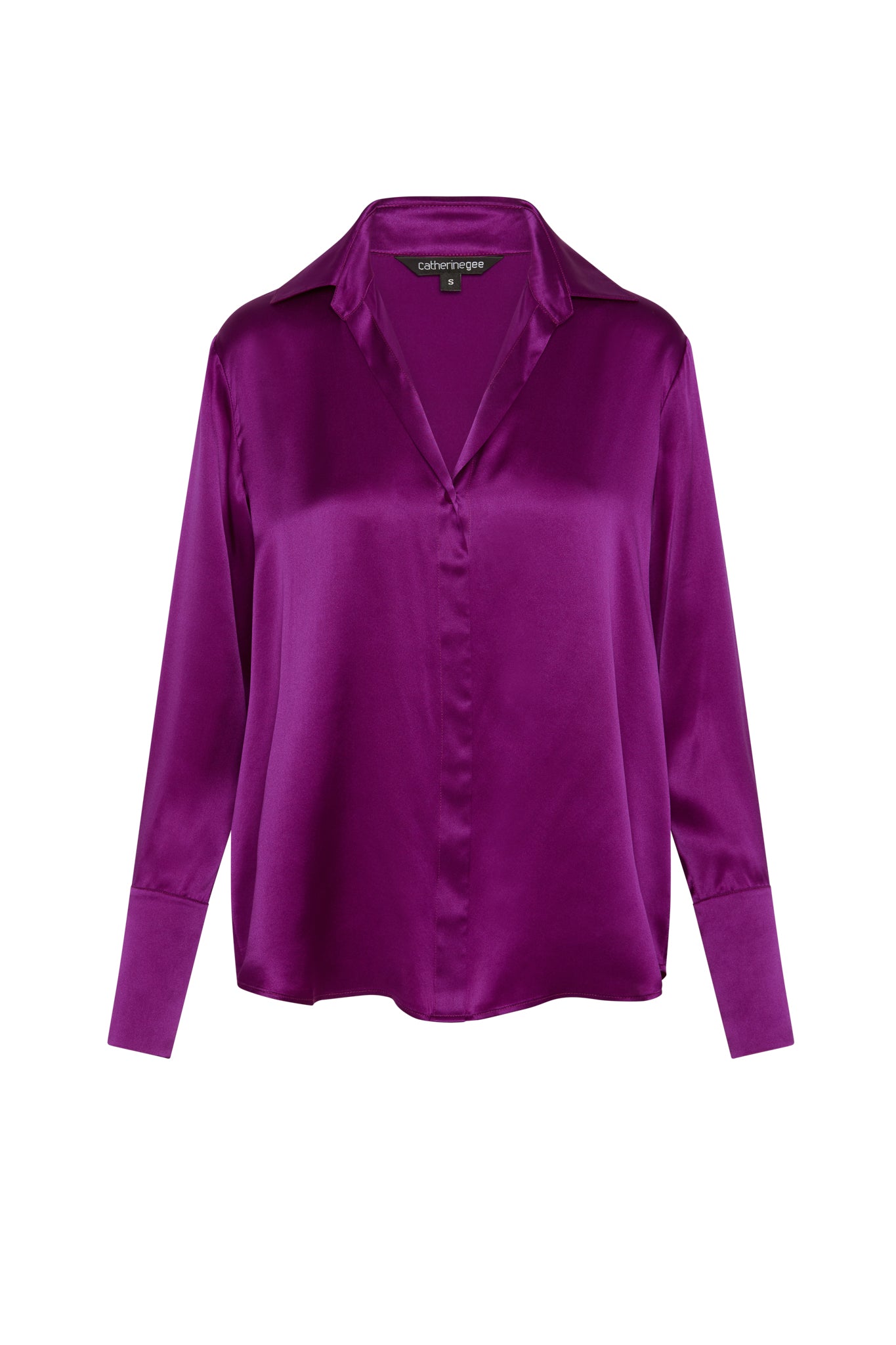 Catherine Gee Daria French Cuff Silk Blouse Electric Orchid features a luxurious, silky texture with a deep V-neckline, long sleeves, and French cuffs. The vibrant purple hue adds a bold and elegant touch to the garment.