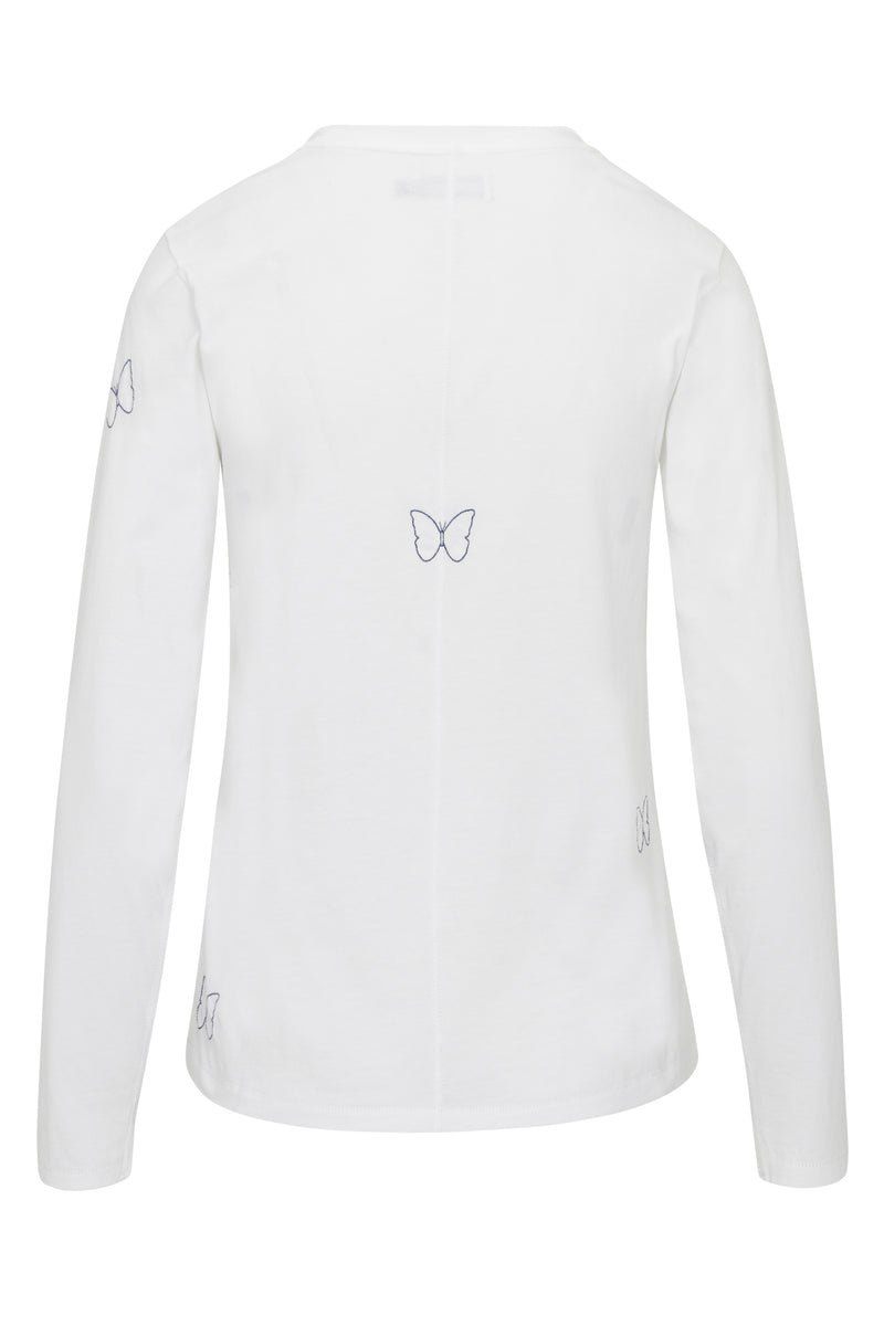 Back-view of a Catherine Gee Embroidered Cotton Long Sleeve Butterfly white t-shirt features subtle embroidered butterfly designs in blue thread, with one butterfly centered on the upper back and smaller butterflies on the sleeves and lower back. The simple, elegant design with long sleeves and a straight hem is enhanced by the delicate, feminine embroidery, making it a stylish and charming piece.