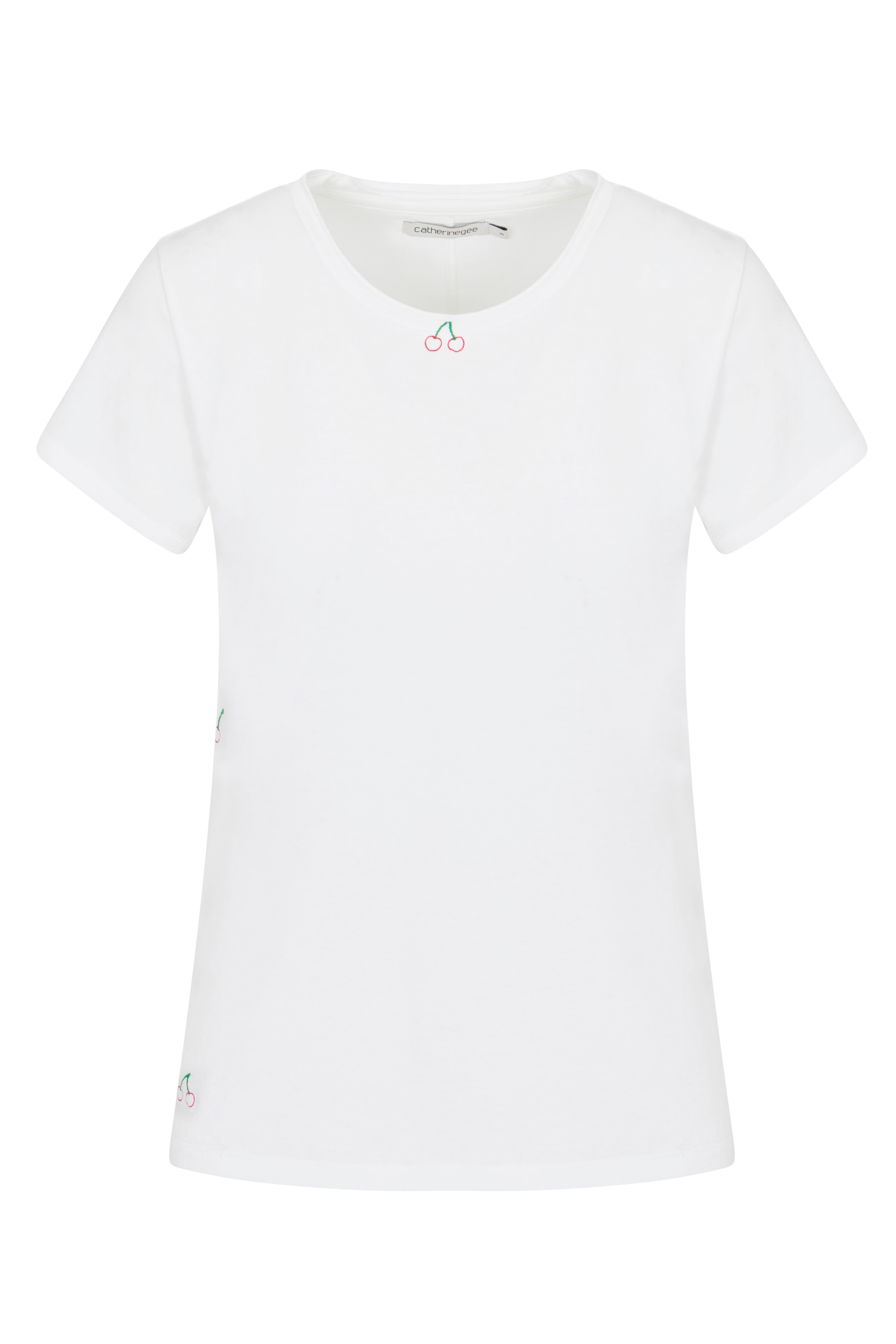 Catherine Gee Embroidered Cotton Cherry t-shirt features a simple yet elegant design with small embroidered cherry motifs. One cherry embroidery is located near the neckline, and there are additional cherry embroideries subtly placed on the sides and near the bottom hem. The t-shirt has a classic round neckline and short sleeves, making it a versatile and stylish piece for casual wear.