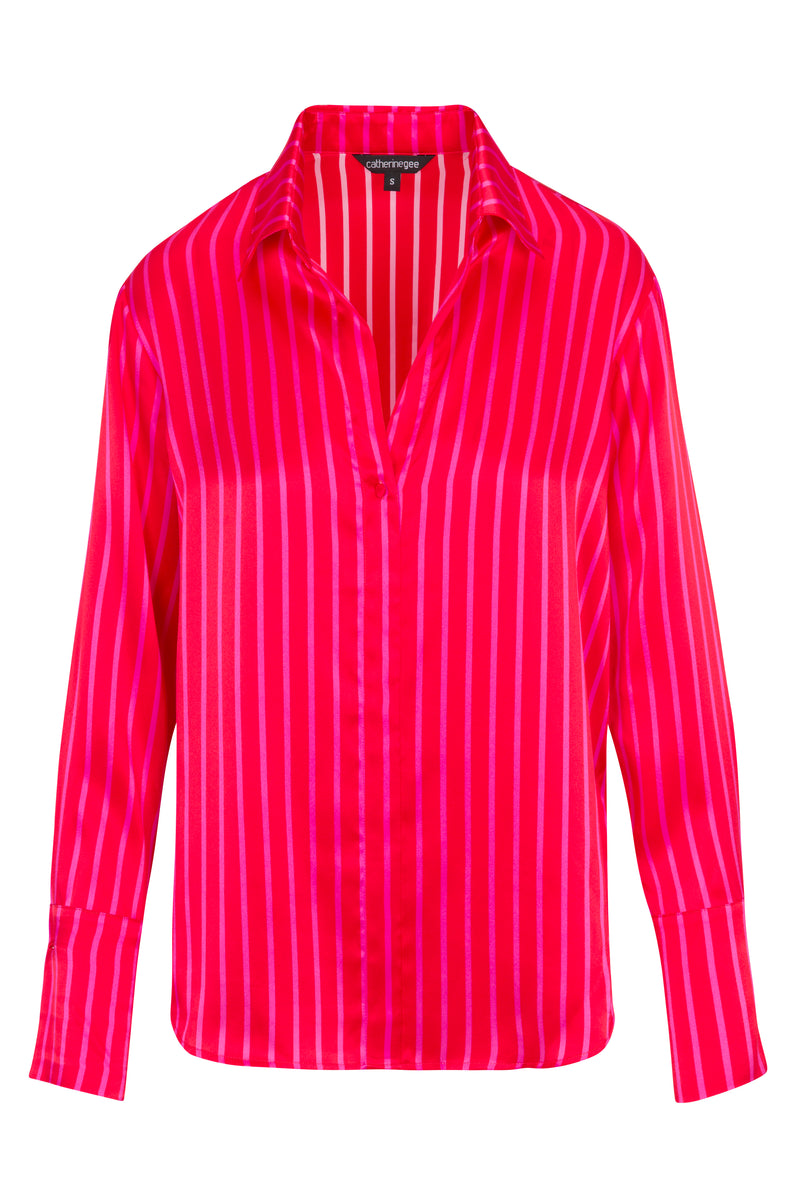 Catherine Gee Daria French Cuff Silk Red/Pink Stripe blouse features a classic collar, a deep V-neckline, and long sleeves with French cuffs. The vertical stripes create a visually elongating effect, and the silk fabric gives it a luxurious sheen. This blouse is both stylish and elegant, making it a versatile piece for various occasions.