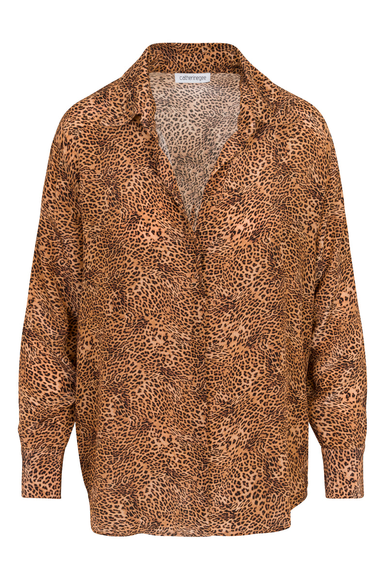 Catherine Gee Dakota Blouse - Clean Leopard. The blouse features a classic collar, long sleeves, and a relaxed fit with a button-down front. The fabric showcases a detailed leopard print pattern in shades of brown and black.