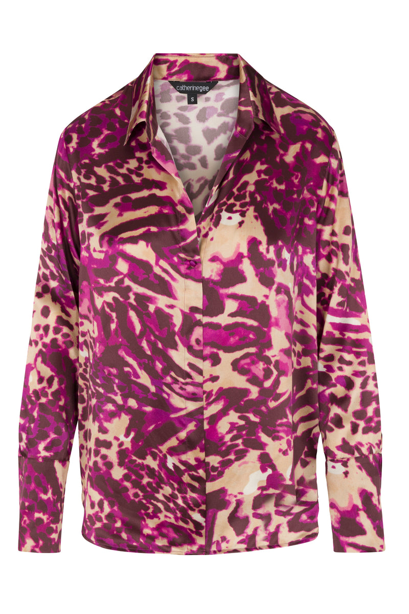 A Catherine Gee Daria French Cuff Silk-Fuchsia Feline blouse features a bold animal pattern in shades of fuchsia, purple, and beige, with a classic collar and button-down front. The long sleeves end in French cuffs, adding a touch of elegance to the striking design.