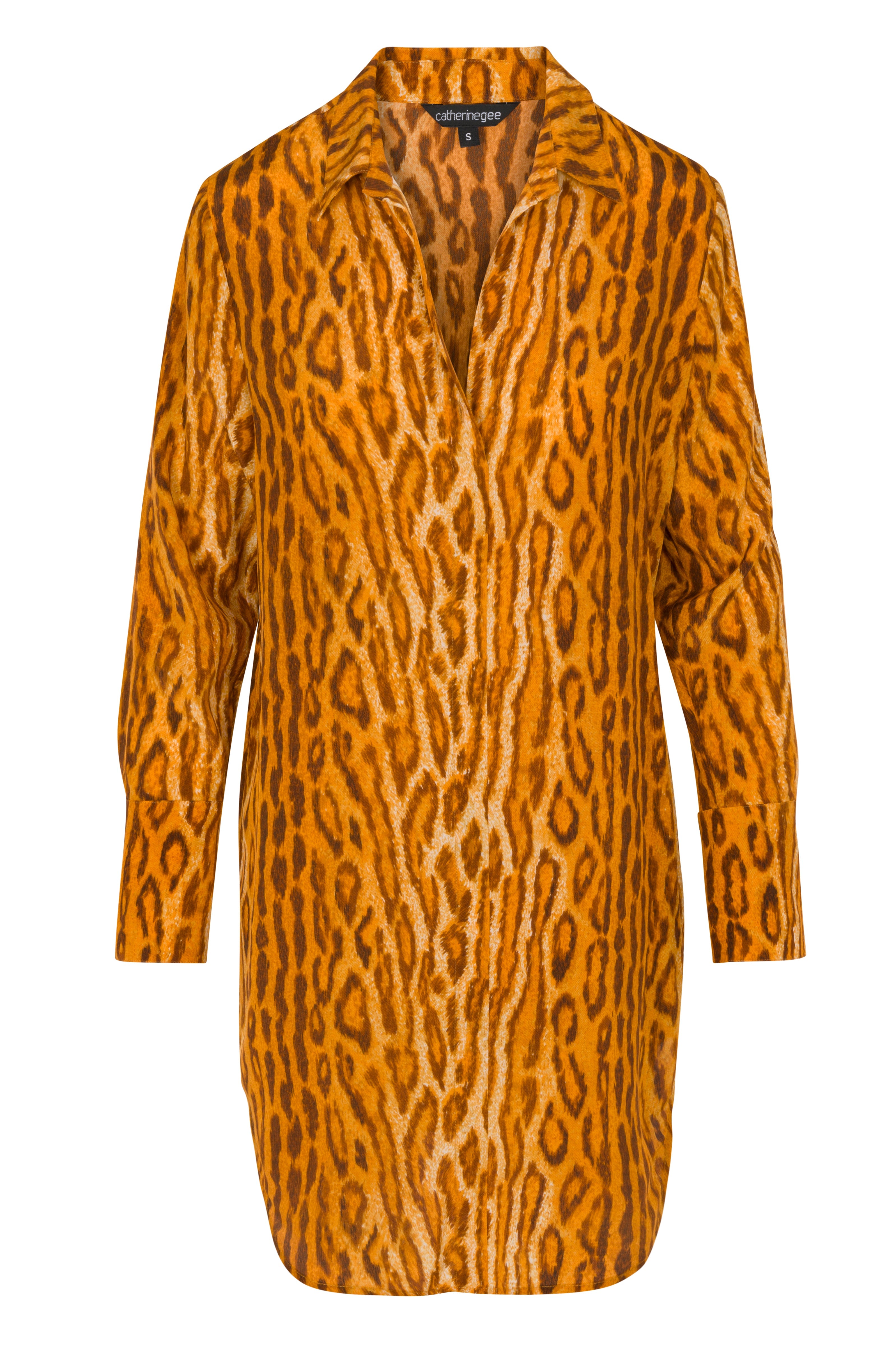 Catherine Gee Warm Leopard Daria Dress features a bold, all-over leopard pattern in shades of orange and brown, with a collared neckline and long sleeves. The design is loose-fitting and extends to mid-thigh length.