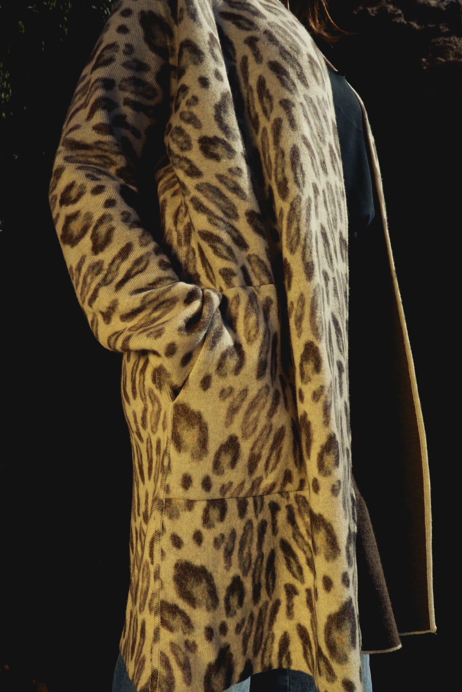 Catherine Gee Double Face Cashmere Reversible New Leopard coat features a luxurious leopard print pattern, with a soft and plush texture indicative of high-quality cashmere. The design is reversible, offering versatility in styling, and has a relaxed fit with long sleeves and pockets, making it both fashionable and functional. The rich, detailed pattern and the premium material make this coat a standout piece in any wardrobe.