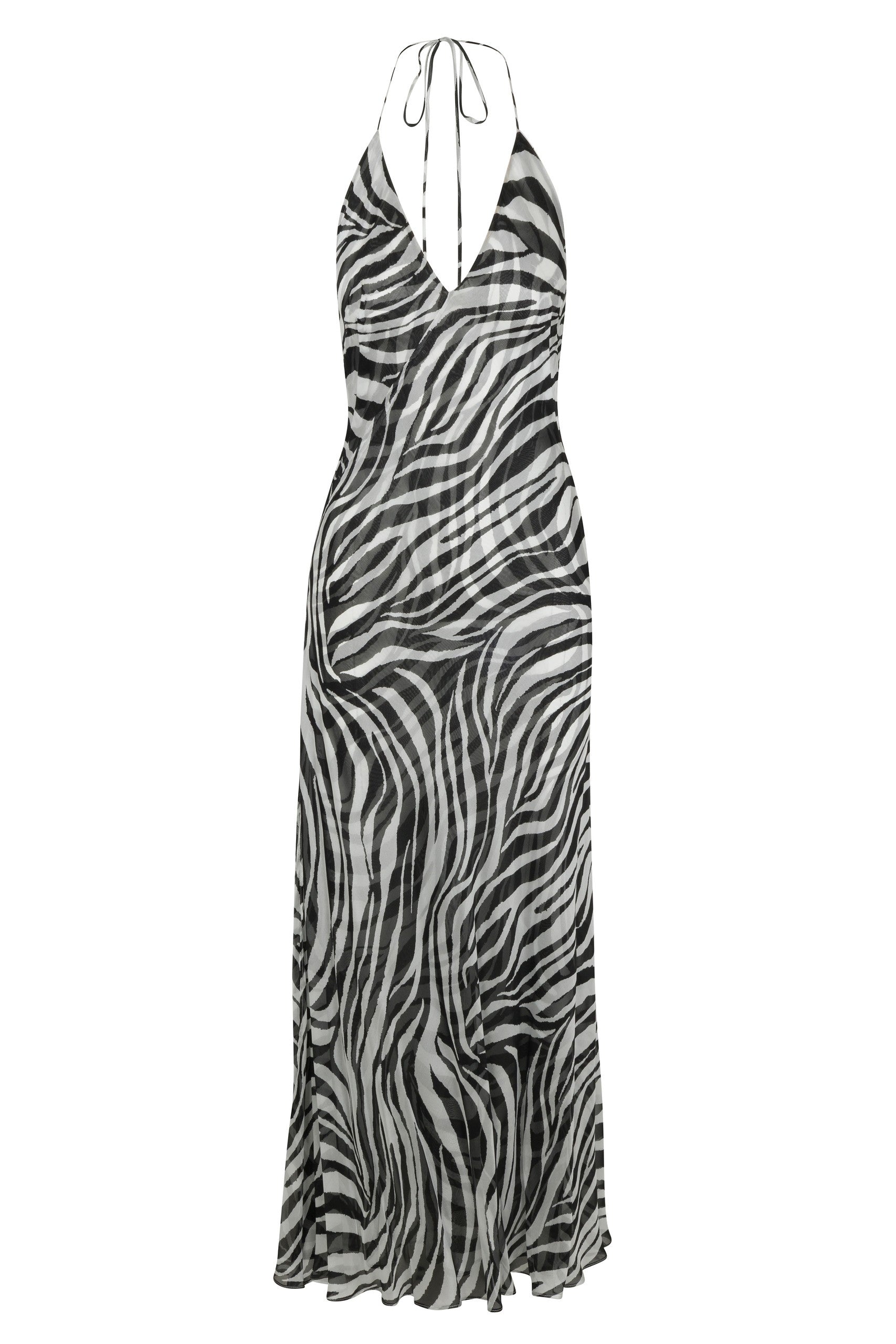 Catherine Gee Halter Zebra dress features a striking zebra print pattern in black and white. It has a halter neckline with thin straps that tie at the back of the neck, creating a deep V-shaped front. The dress is long, flowing down to the ankles, and appears to be made of a lightweight, sheer fabric, giving it an elegant and breezy look. The zebra print adds a bold and fashionable touch, making it a standout piece for various occasions.