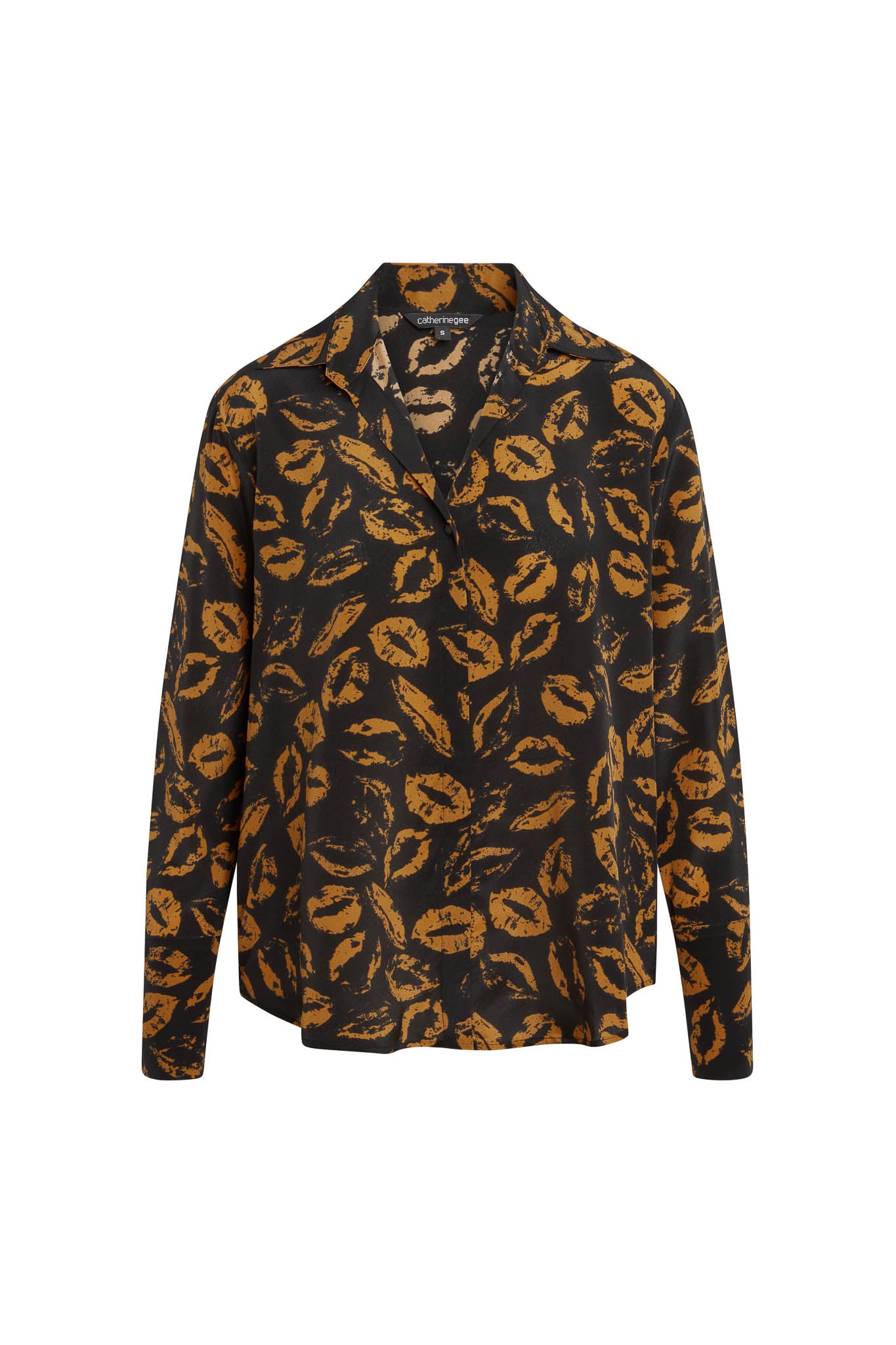 Catherine Gee Daria French Cuff Silk Mocha Lips blouse is made of luxurious silk with a smooth, shiny finish featuring a black background with an all-over print of mocha-colored lips. The blouse has a classic collar, long sleeves with French cuffs, and a relaxed fit. The design is both stylish and unique, making it an interesting piece for fashion enthusiasts.