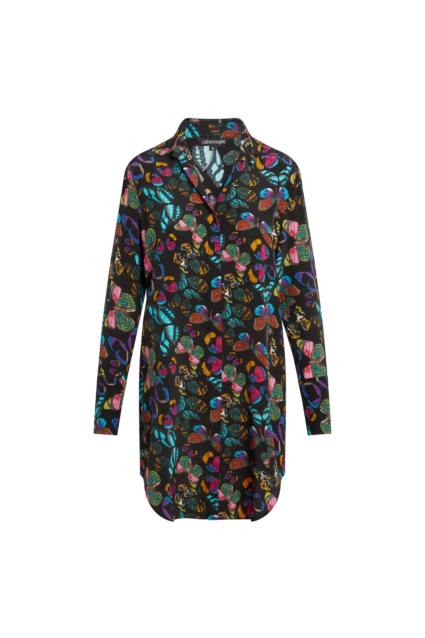 Catherine Gee Daria Silk Shirt The Tracy stylish dress features a vibrant, multicolored butterfly with various abstract shapes on a black background. It has long sleeves, a button-down front, and a collar, providing a sophisticated yet playful look. The luxurious silk fabric adds a touch of elegance, making it both fashionable and comfortable for various occasions.