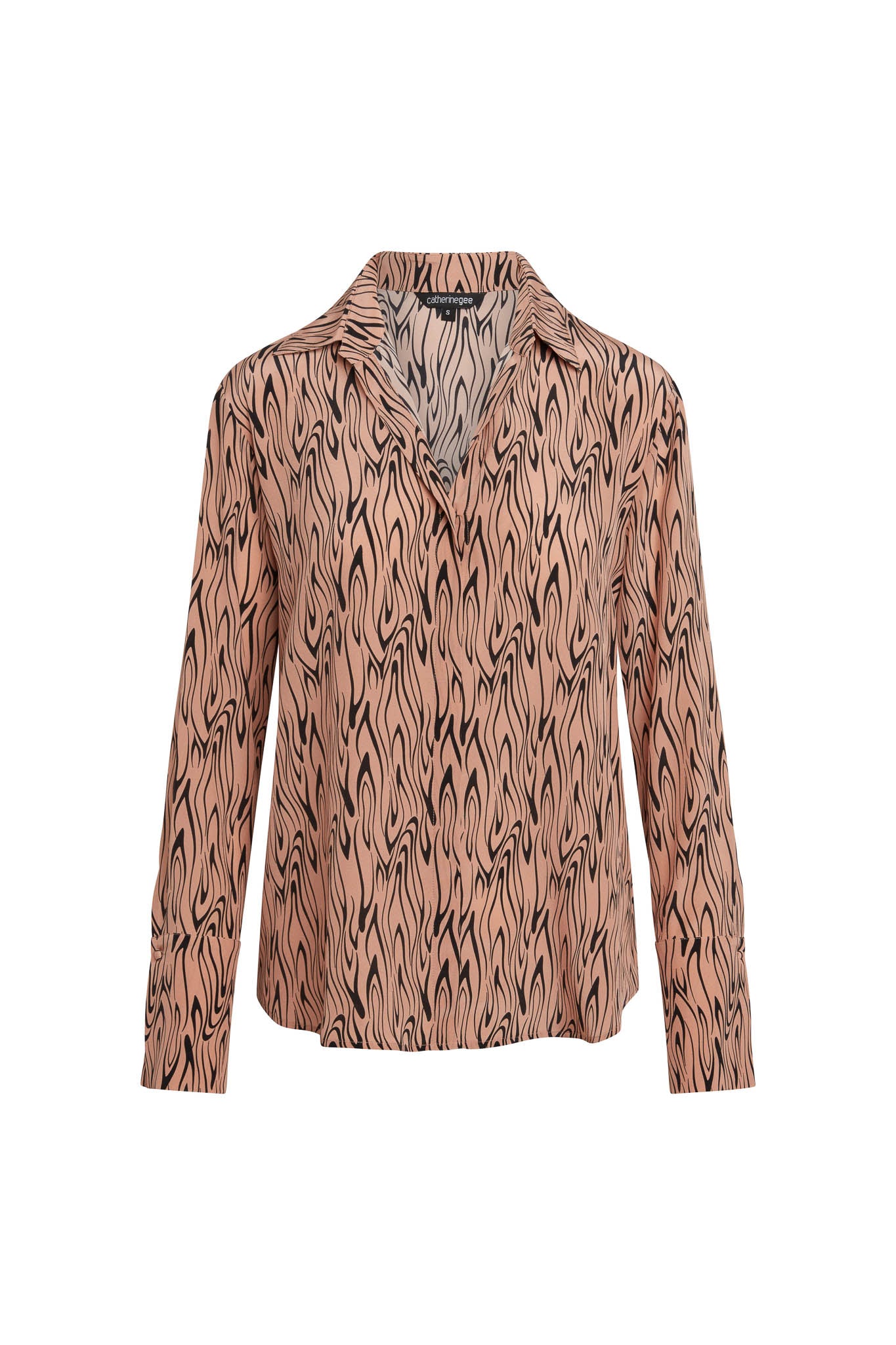 Catherine Gee Daria French Cuff Silk Wishbone blouse features a unique wishbone pattern in black on a peach-colored silk fabric. It has a classic collar, long sleeves with French cuffs, and a relaxed fit. The design is elegant and sophisticated, making it a versatile piece suitable for both professional and casual settings. The silk material adds a luxurious touch to the overall appearance.