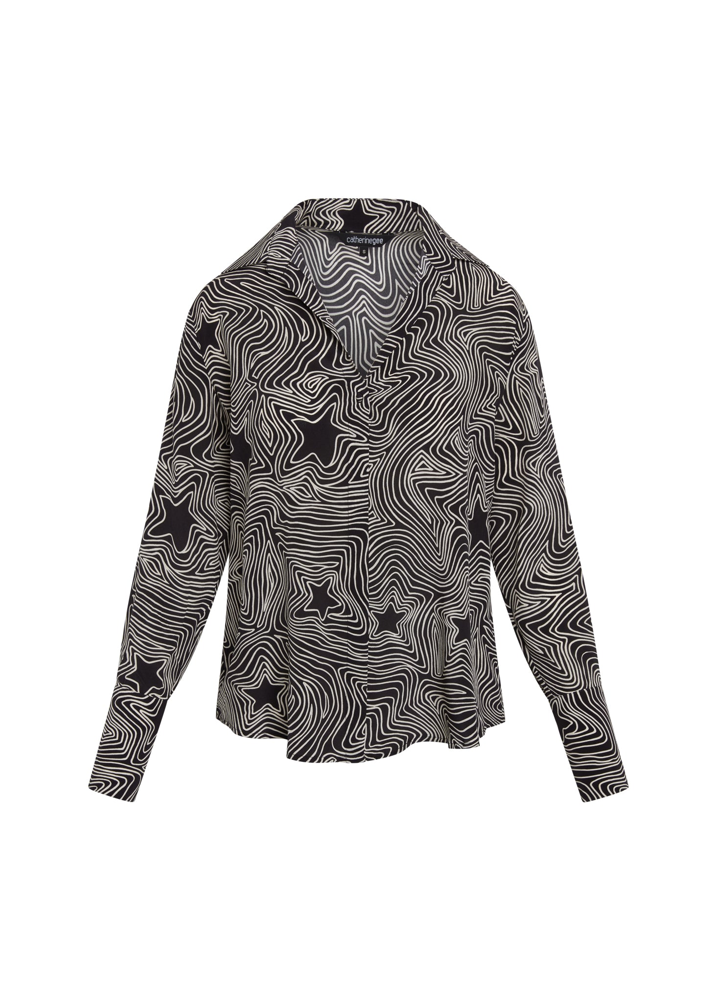 Catherine Gee Daria French Cuff Silk Blouse Bowie Star. A black silk blouse with a white wavy line pattern and black star shapes, featuring a V-neck and long sleeves with French cuffs.