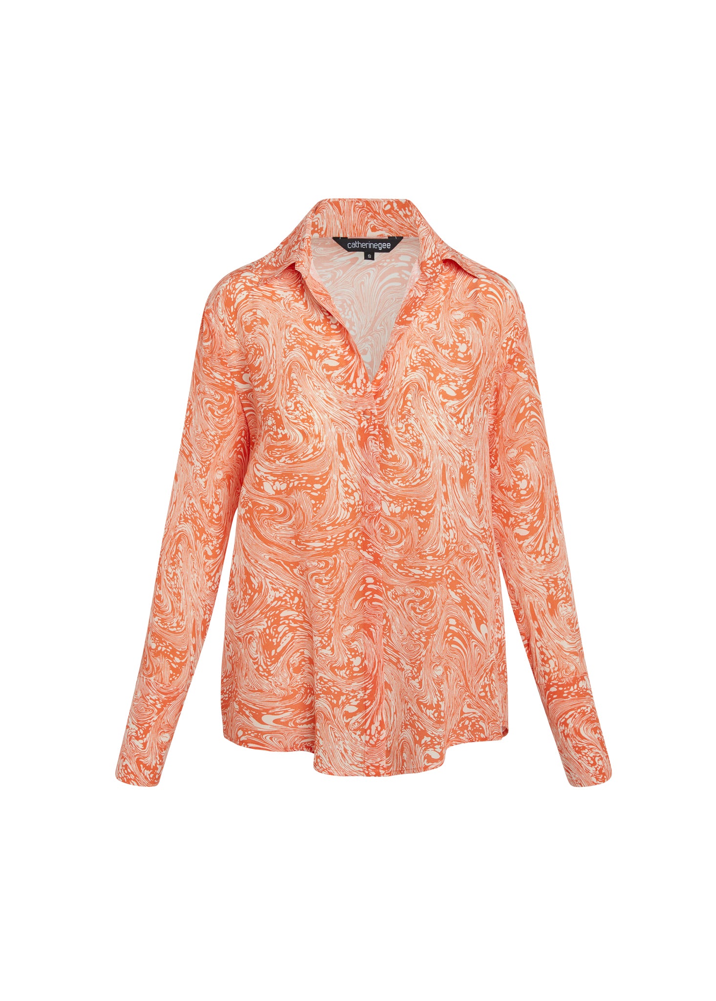 Catherine Gee Daria French Cuff Silk Sorbet Swirl blouse features a vibrant orange and white swirl pattern, reminiscent of a marbled design. It has a classic collar, long sleeves with French cuffs, and a relaxed fit. The fabric appears to be lightweight and silky, making it suitable for both casual and semi-formal occasions. The intricate pattern and luxurious material make this blouse a standout piece in any wardrobe.