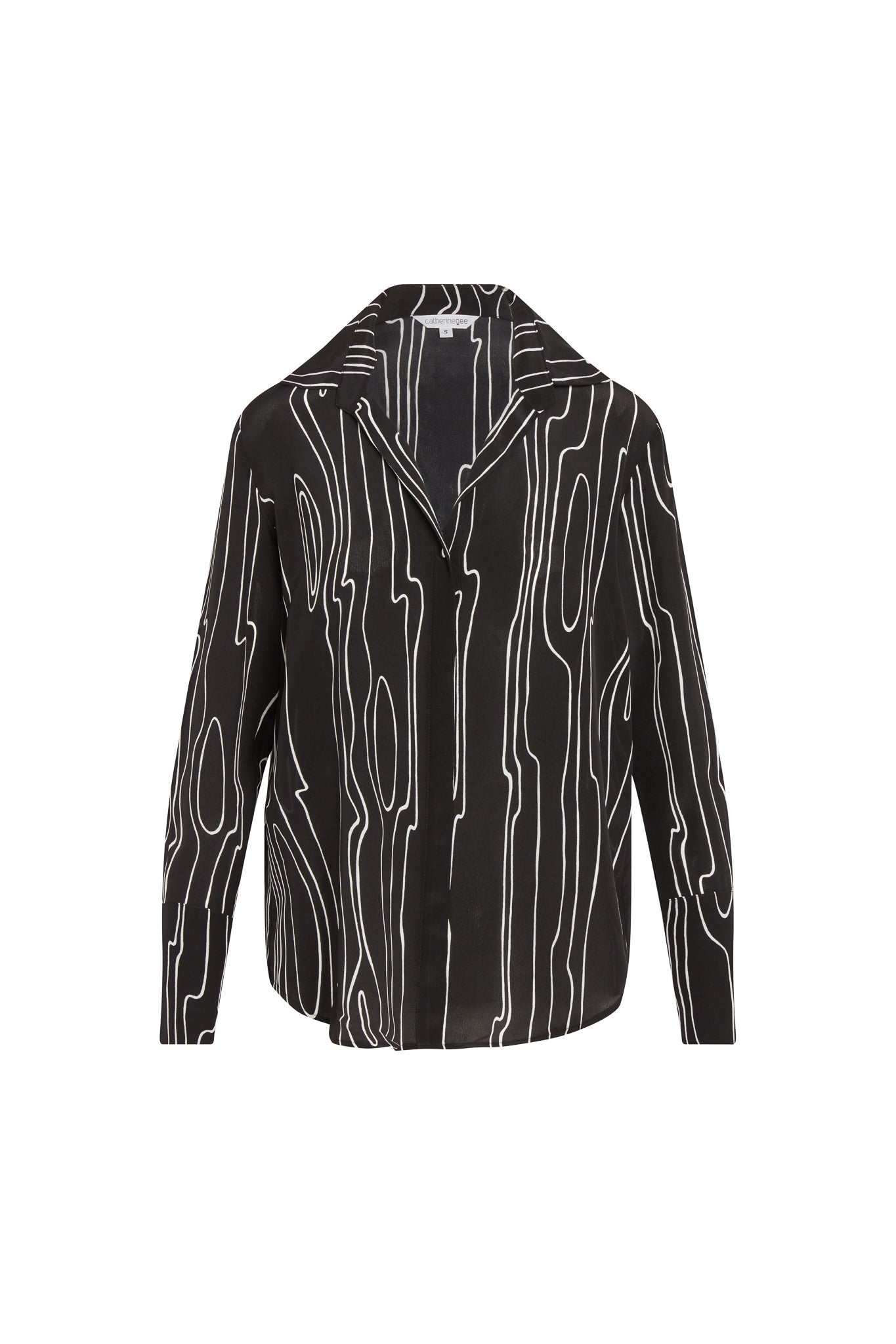 Catherine Gee Daria French Cuff Silk Blouse Byrne. A black silk blouse with a white abstract woodgrain pattern, featuring a pointed collar and long sleeves with French cuffs.