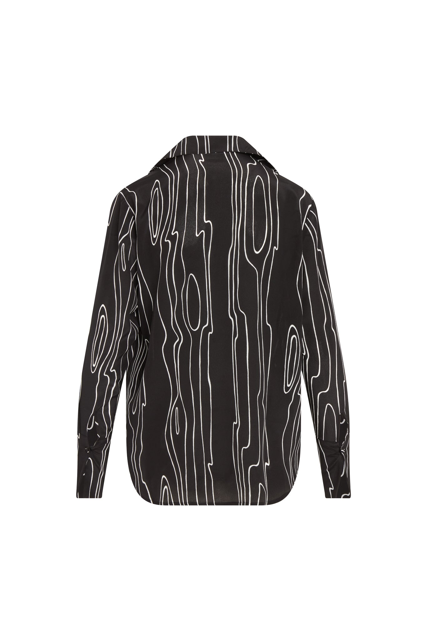 Back view of a Catherine Gee Daria French Cuff Silk Blouse Byrne. A black silk blouse features a black base with an abstract white line design resembling wood grain. It has long sleeves with French cuffs and a classic collar.