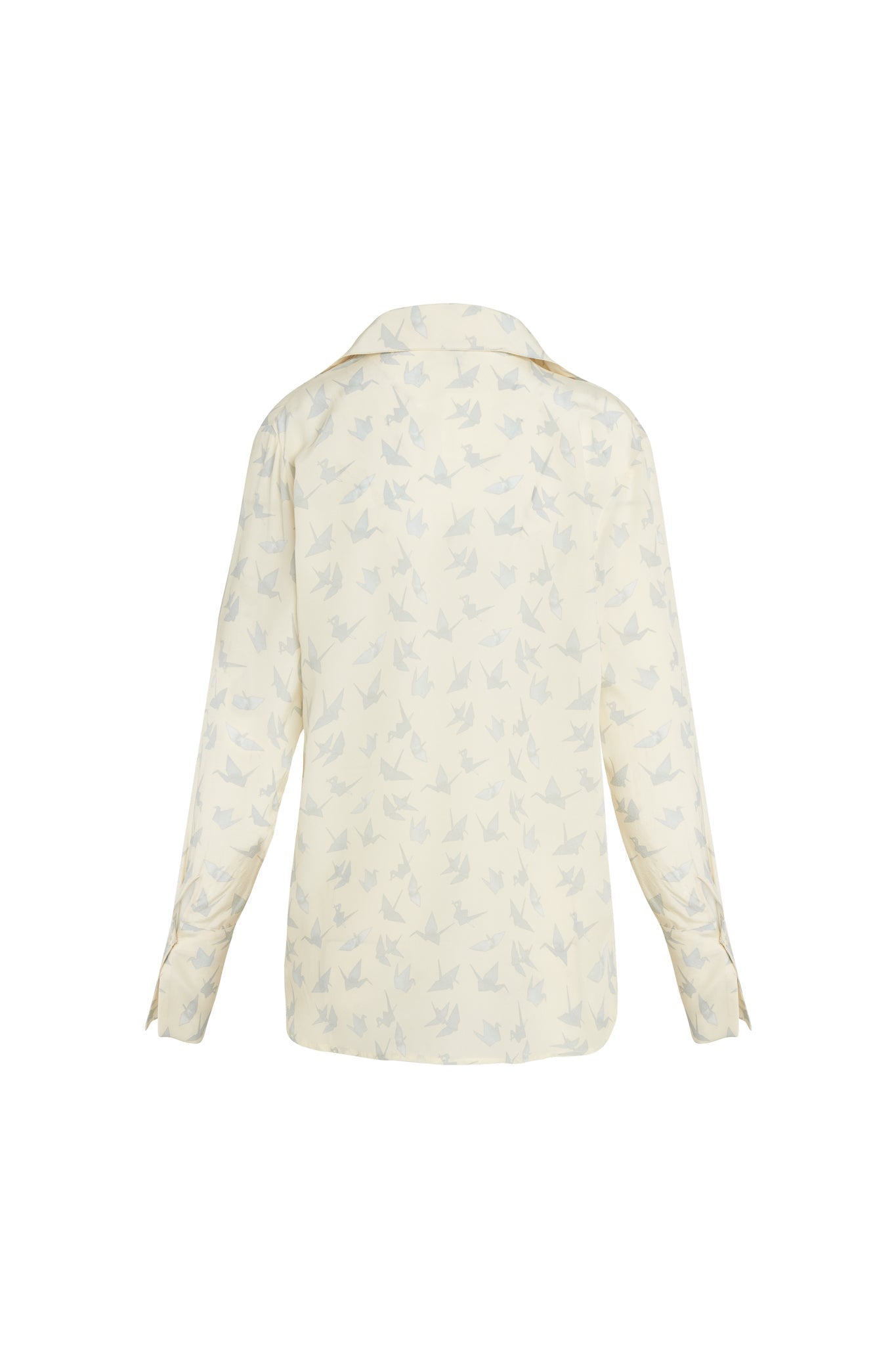 Back-view of a Catherine Gee Daria French Cuff Silk Neutral Crane blouse features a light, neutral-colored silk fabric and a subtle crane pattern printed all over. The blouse has long sleeves with French cuffs and a classic collar. The design is elegant and sophisticated, making it suitable for both professional and casual settings. The crane pattern adds a unique and delicate touch to the overall appearance of the blouse.