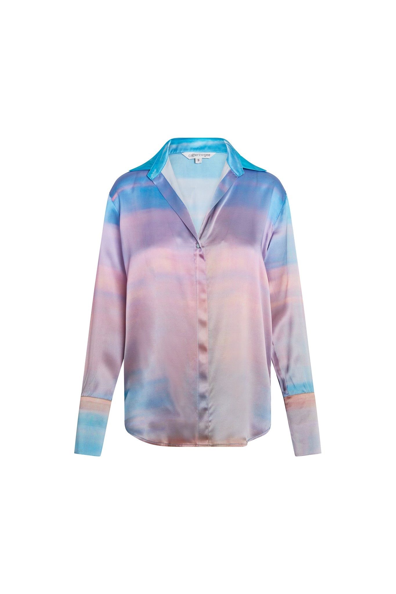 Catherine Gee Daria's French Cuff Silk Peruvian Quartz blouse features a vibrant and elegant design with a blend of pastel colors, including shades of blue, purple, and pink, creating a watercolor-like effect. The blouse has a classic collar, long sleeves with French cuffs, and a concealed button placket down the front, a silk material gives it a luxurious and smooth texture, making it suitable for both casual and formal occasions making the blouse an eye-catching and stylish piece.