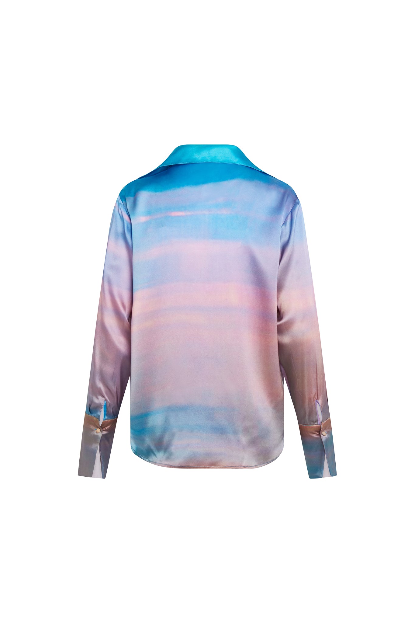 Back-view of a Catherine Gee Daria French Cuff Silk Peruvian Quartz blouse features a gradient design with shades of blue, purple, and pink, resembling a sunset or a watercolor painting. The fabric appears to be silky and smooth, with a slight sheen and has long sleeves with French cuffs and a classic collar. The overall design is elegant and artistic, making it a visually appealing piece of clothing.